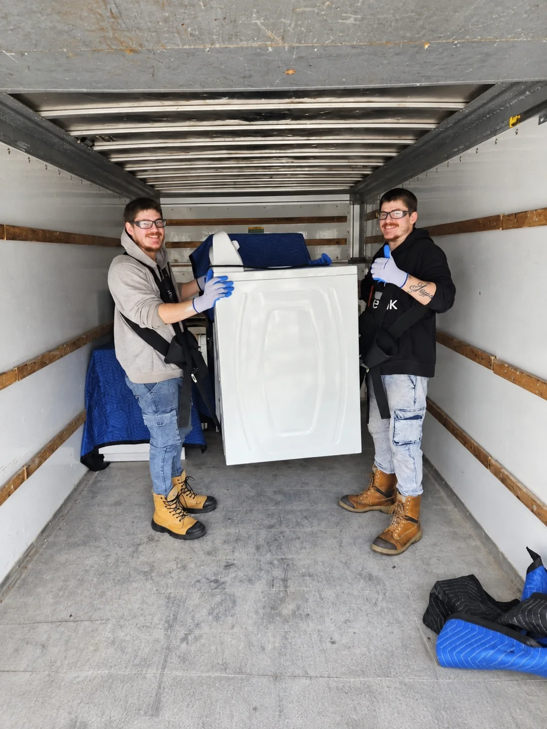 L'équipe RMG transporte un électroménager avec soin